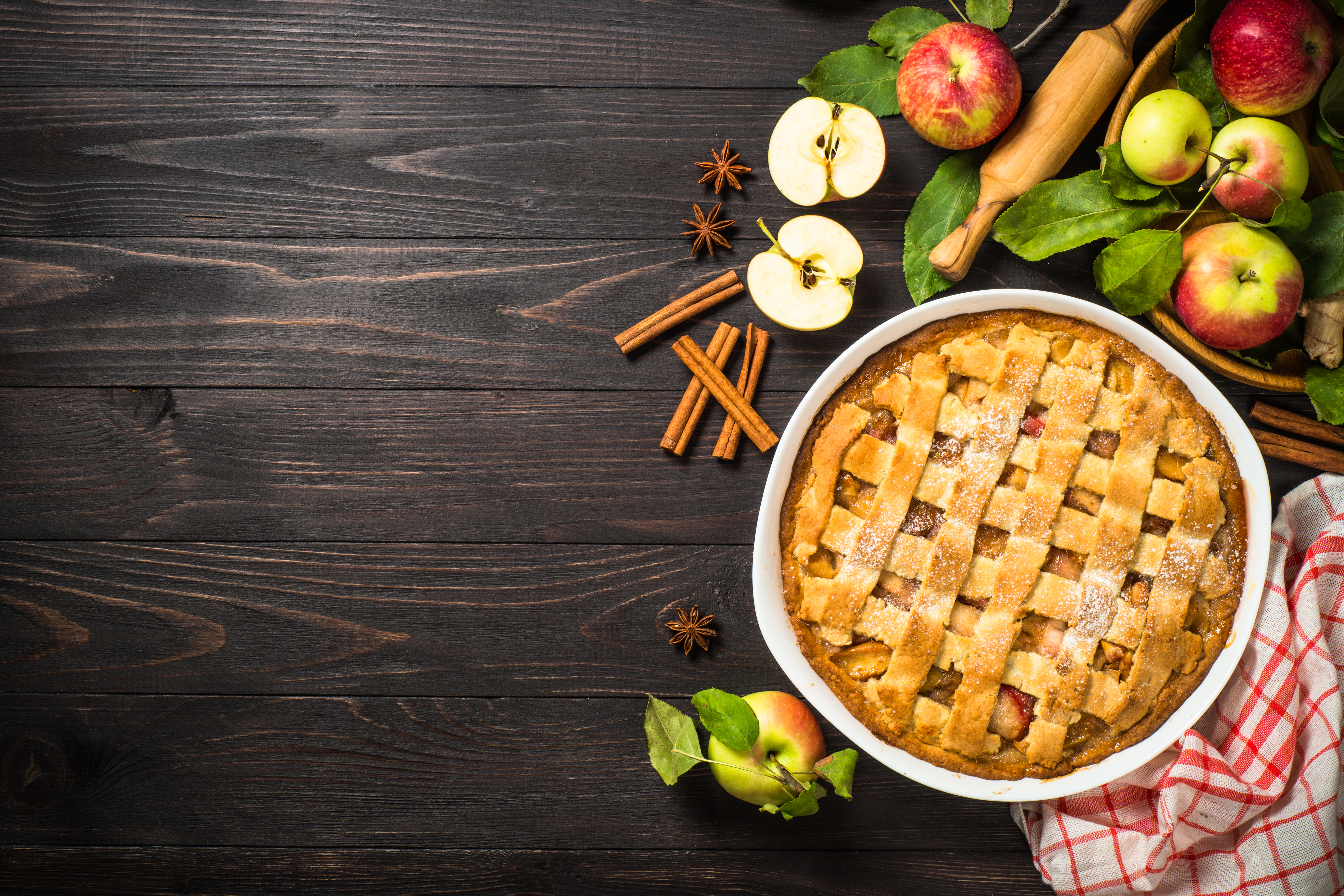 Apple pie with ginger and cinnamon at dark wooden table. 