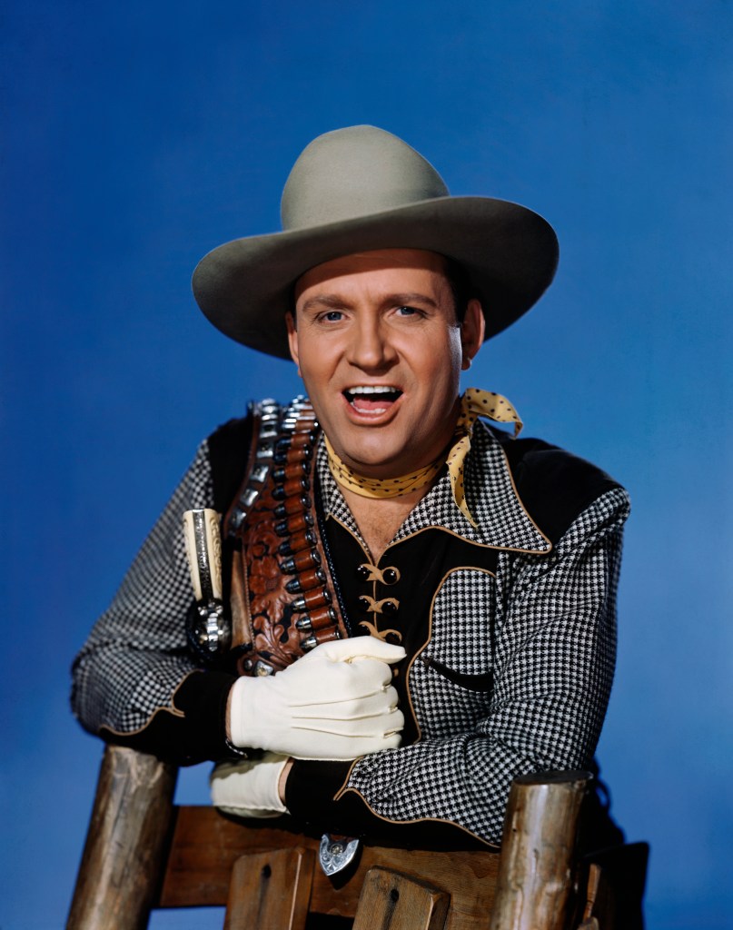 Film cowboy Gene Autry holding his gun belt over his shoulder.