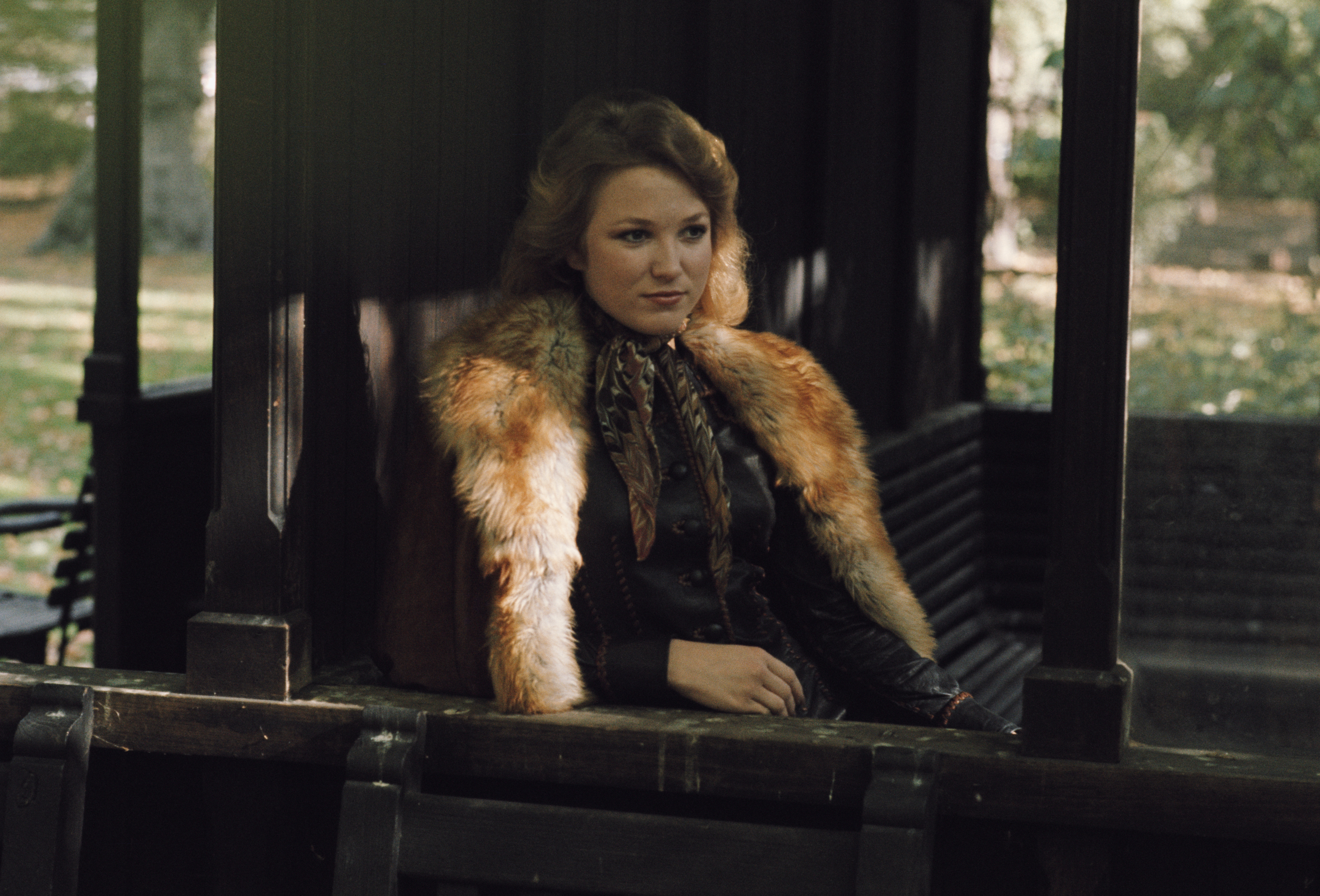 American country music singer-songwriter Tanya Tucker posed sitting on a seat in a London park, 16th October 1975. 
