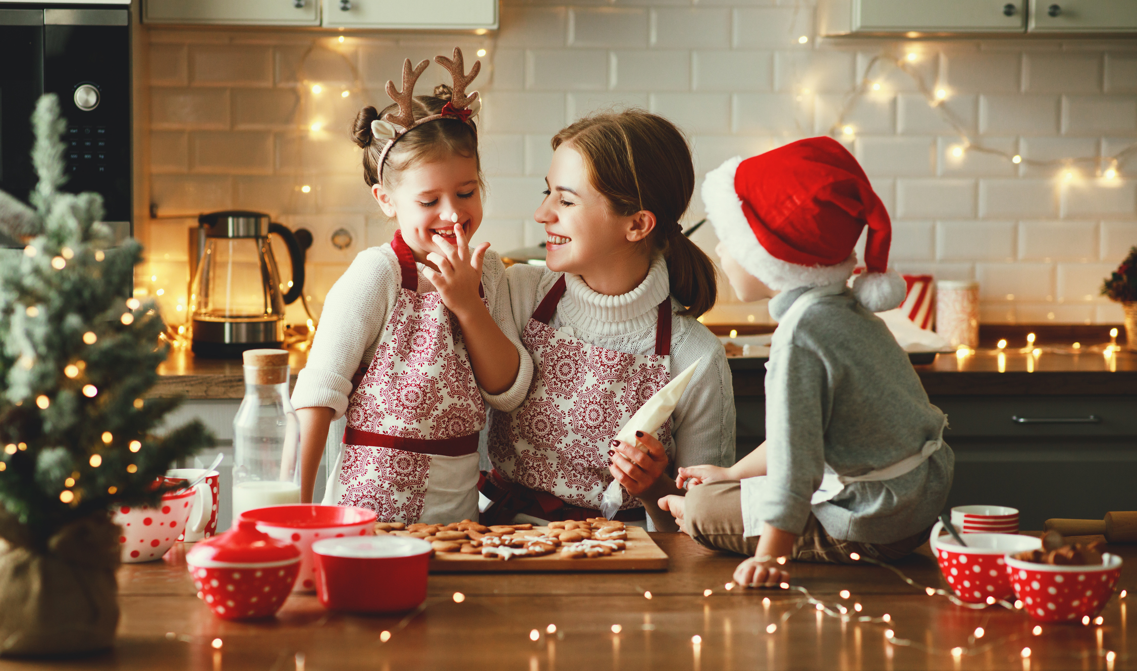 Happy funny family mother and children bake christmas cookies