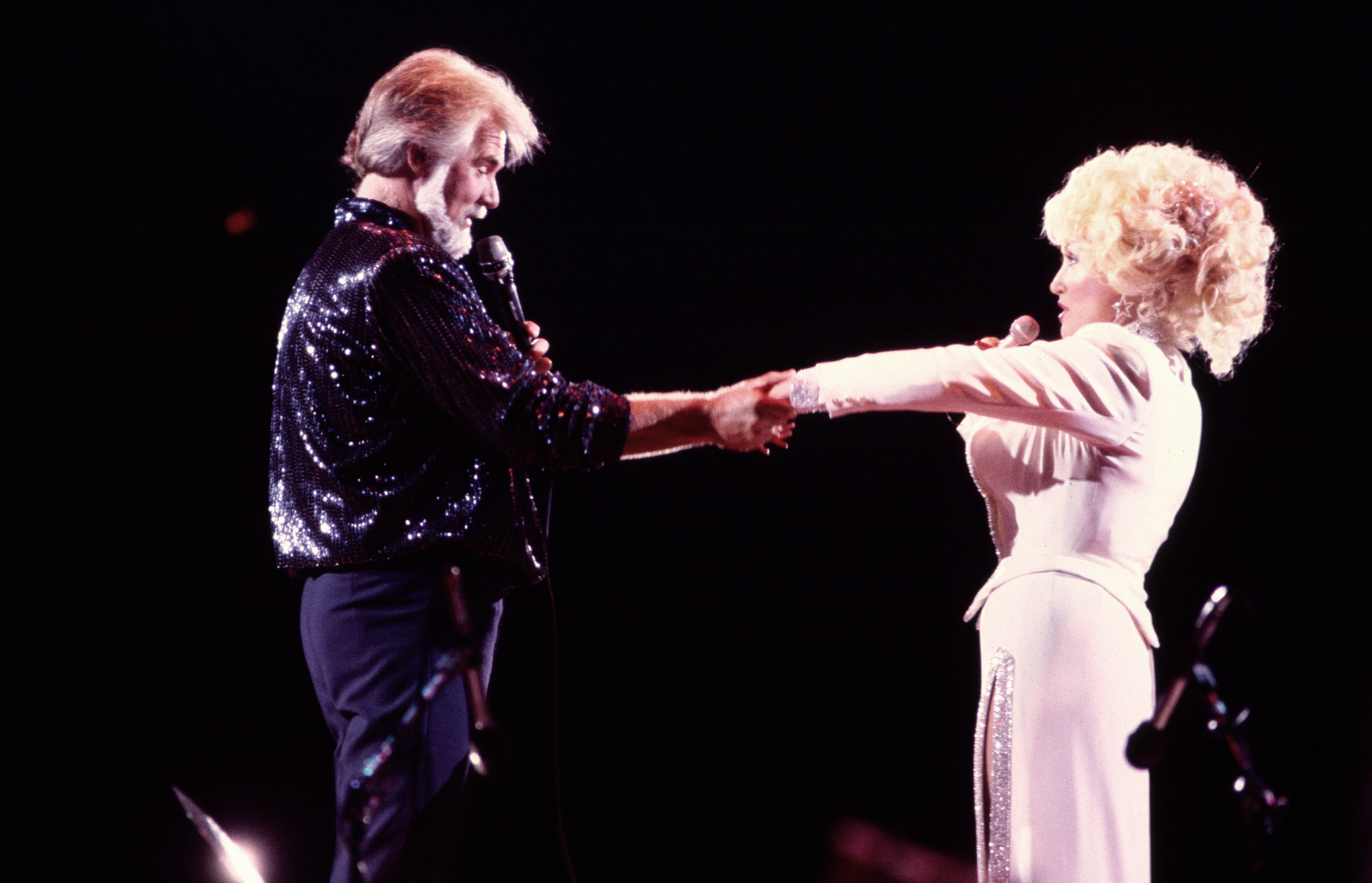 American Country musicians Kenny Rogers (1938 - 2020) and Dolly Parton perform together onstage at Nassau Coliseum, Uniondale, New York, August 29, 1985. 