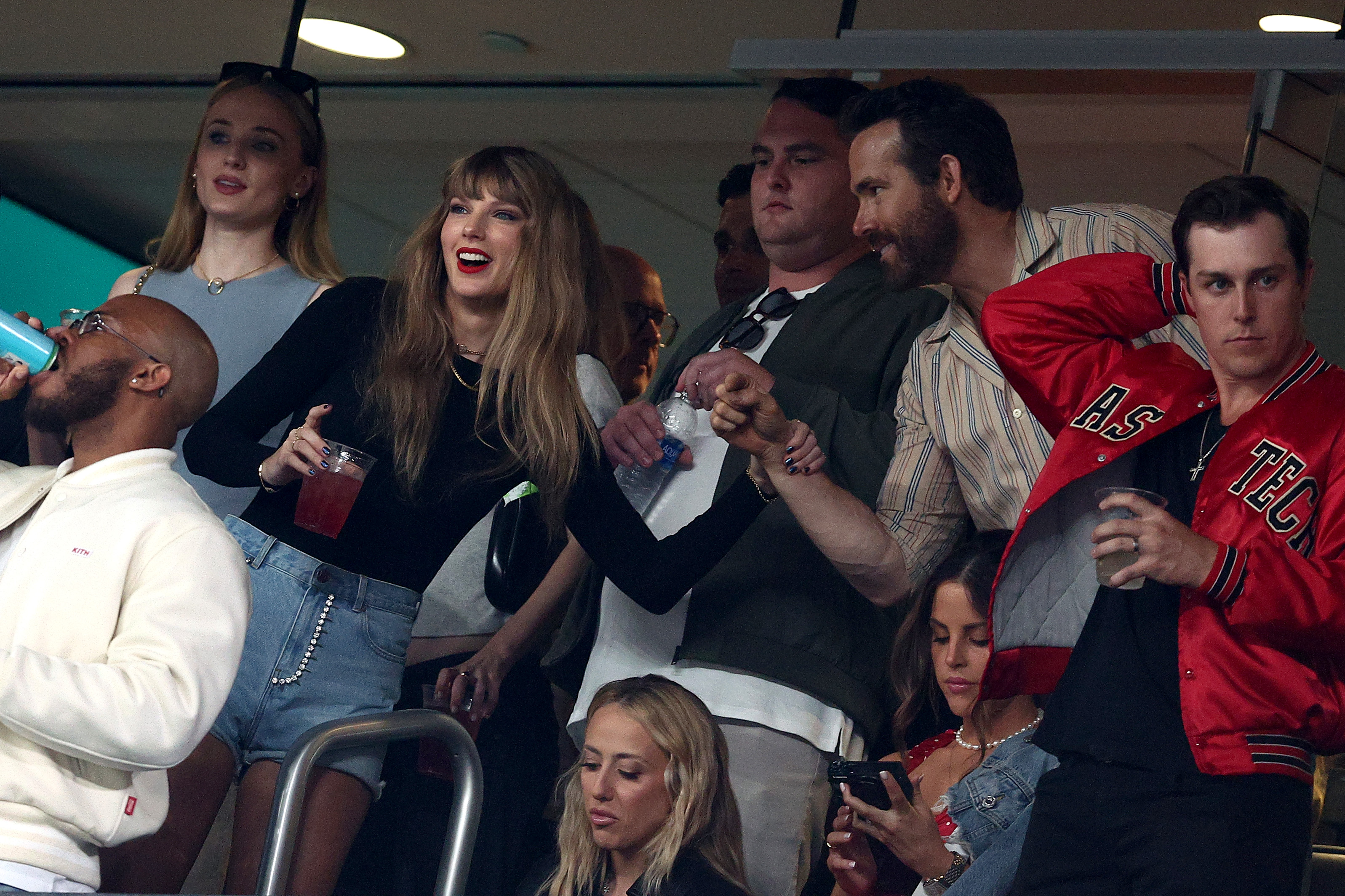 EAST RUTHERFORD, NEW JERSEY - OCTOBER 01: (L-R) Singer Taylor Swift and Actor Ryan Reynolds talk prior to the game between the Kansas City Chiefs and the New York Jets at MetLife Stadium on October 01, 2023 in East Rutherford, New Jersey.