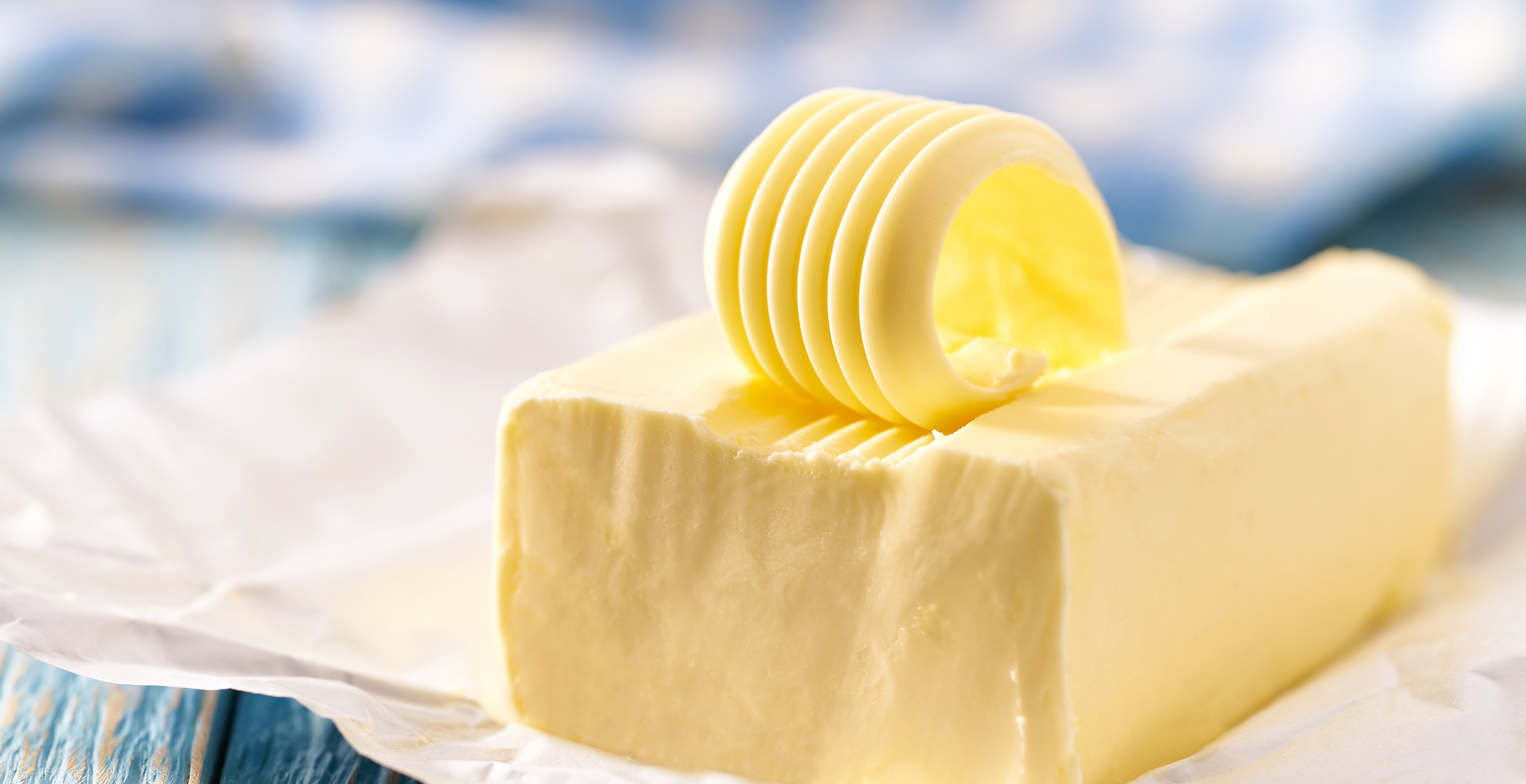 piece of butter on a blue wooden table, selective focus.