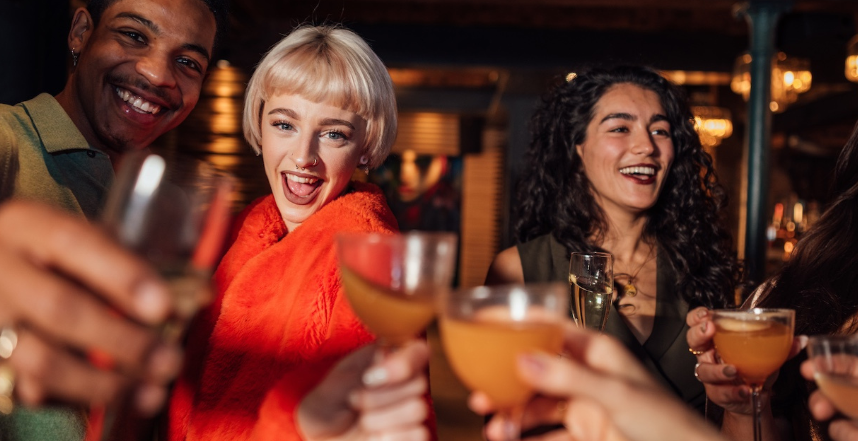 A candid point of view of a group of friends toasting to the new year and the night ahead. They are dancing on the dance floor of a club enjoying a night out in Newcastle upon Tyne in the North East of England.