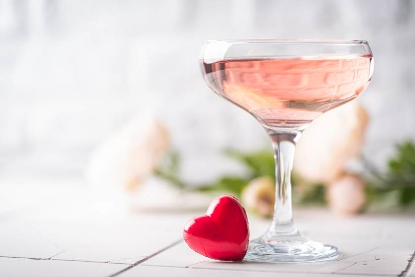 Valentine's day festive cocktail with flowers red heart on a festive white background