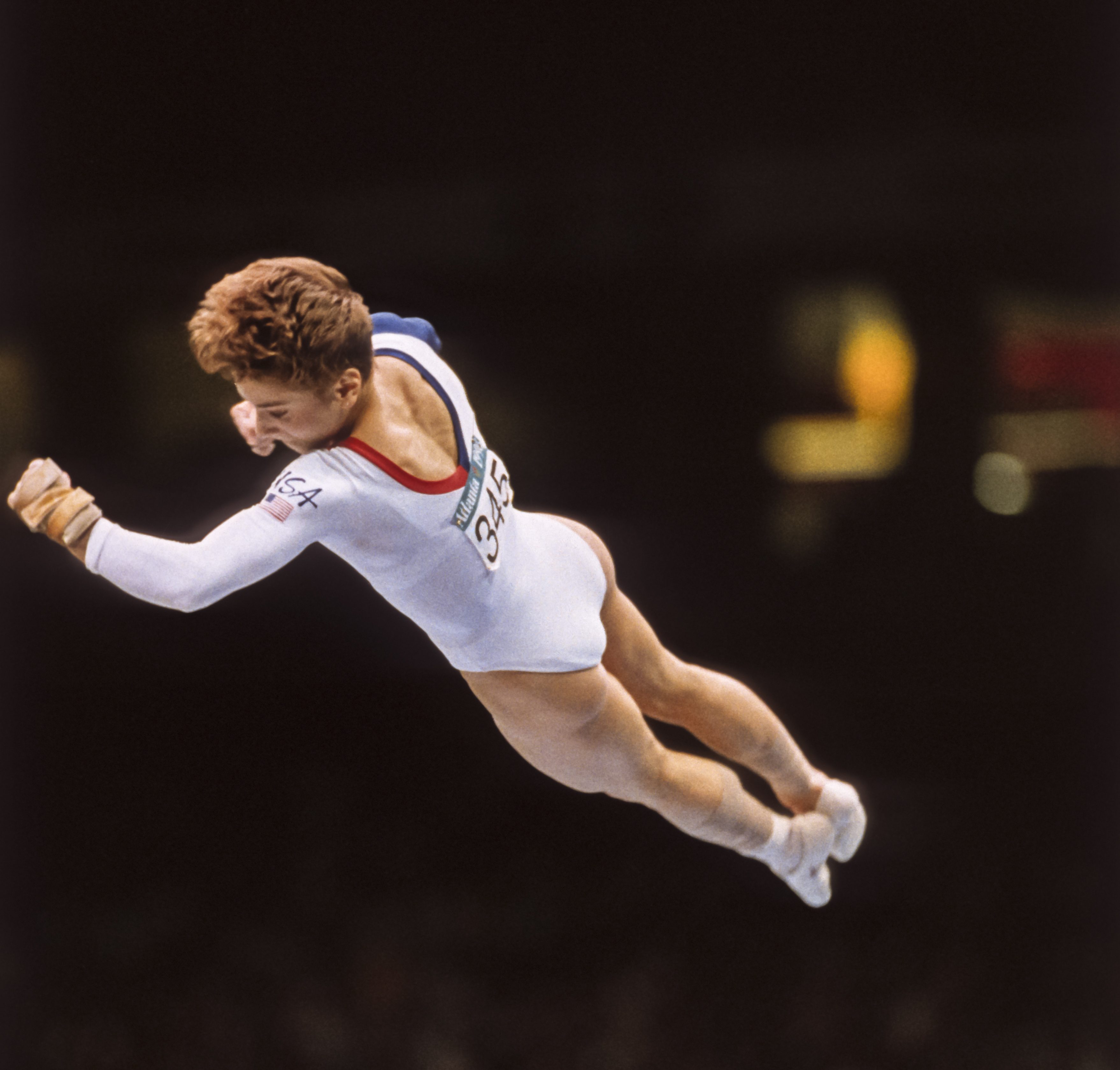 ATLANTA - JULY 23: Kerri Strug of the United States performs a vault during the team competition of the Women's Gymnastics event of the 1996 Summer Olympic Games held on July 23, 1996 in the Georgia Dome in Atlanta, Georgia. Strug was part of the gold medal winning USA Women's team, nicknamed the Magnificent Seven. 