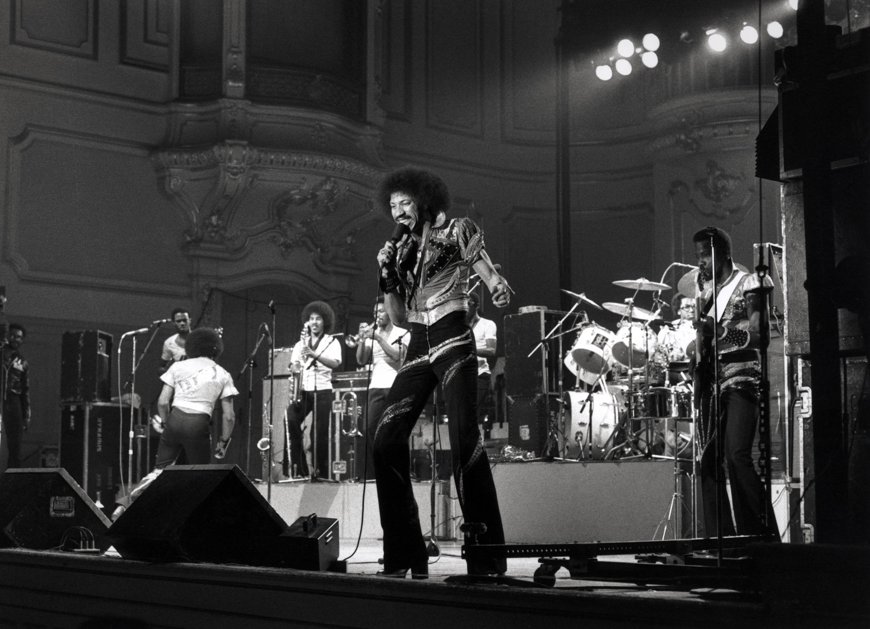 Singer Lionel Richie performing on stage with American funk and soul band, The Commodores, circa 1975