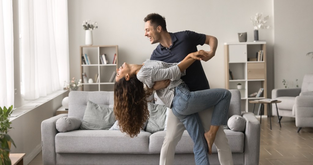 couple dancing together in their living room 