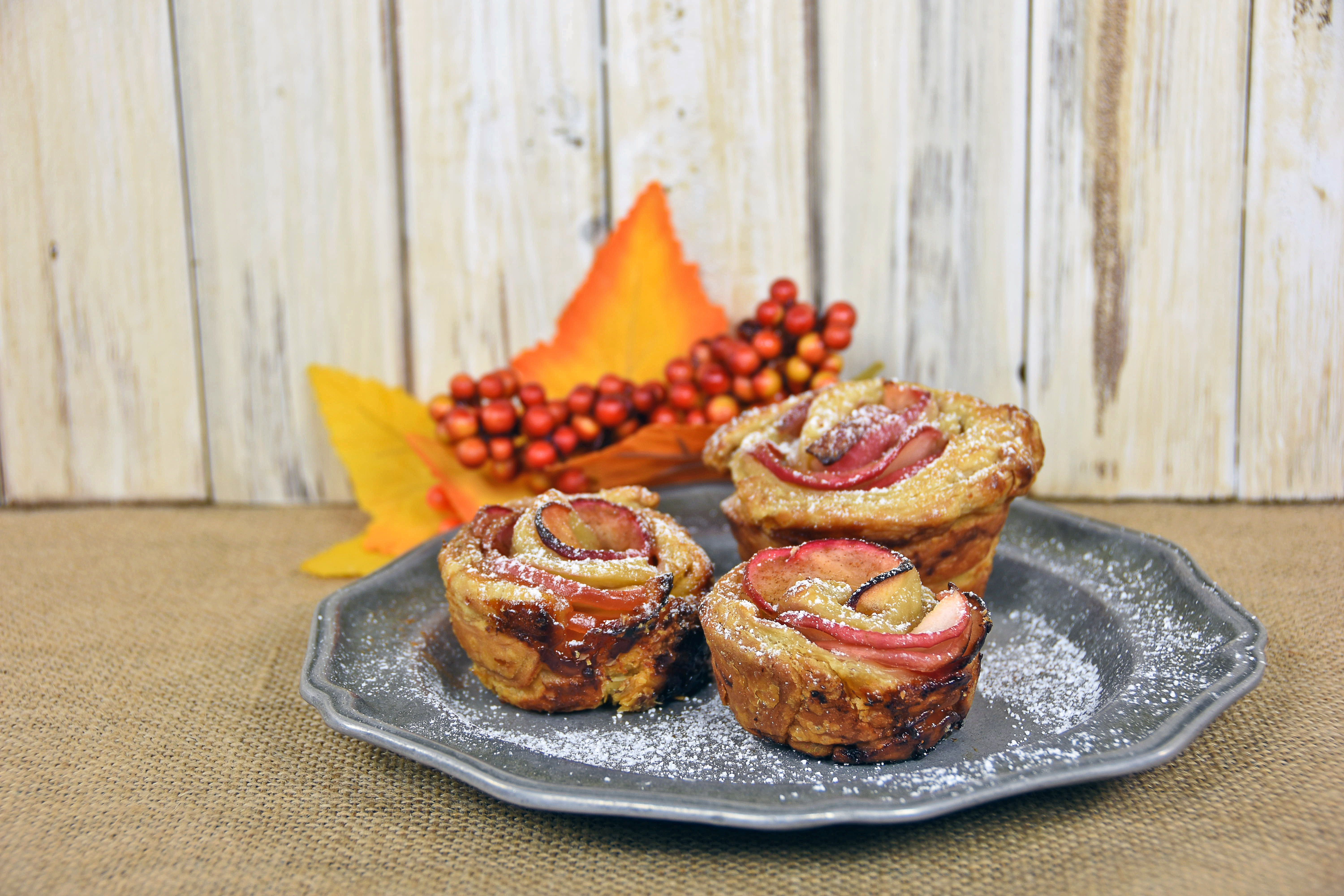 apple rose pastry on pewter plate with autumn leaves and berries