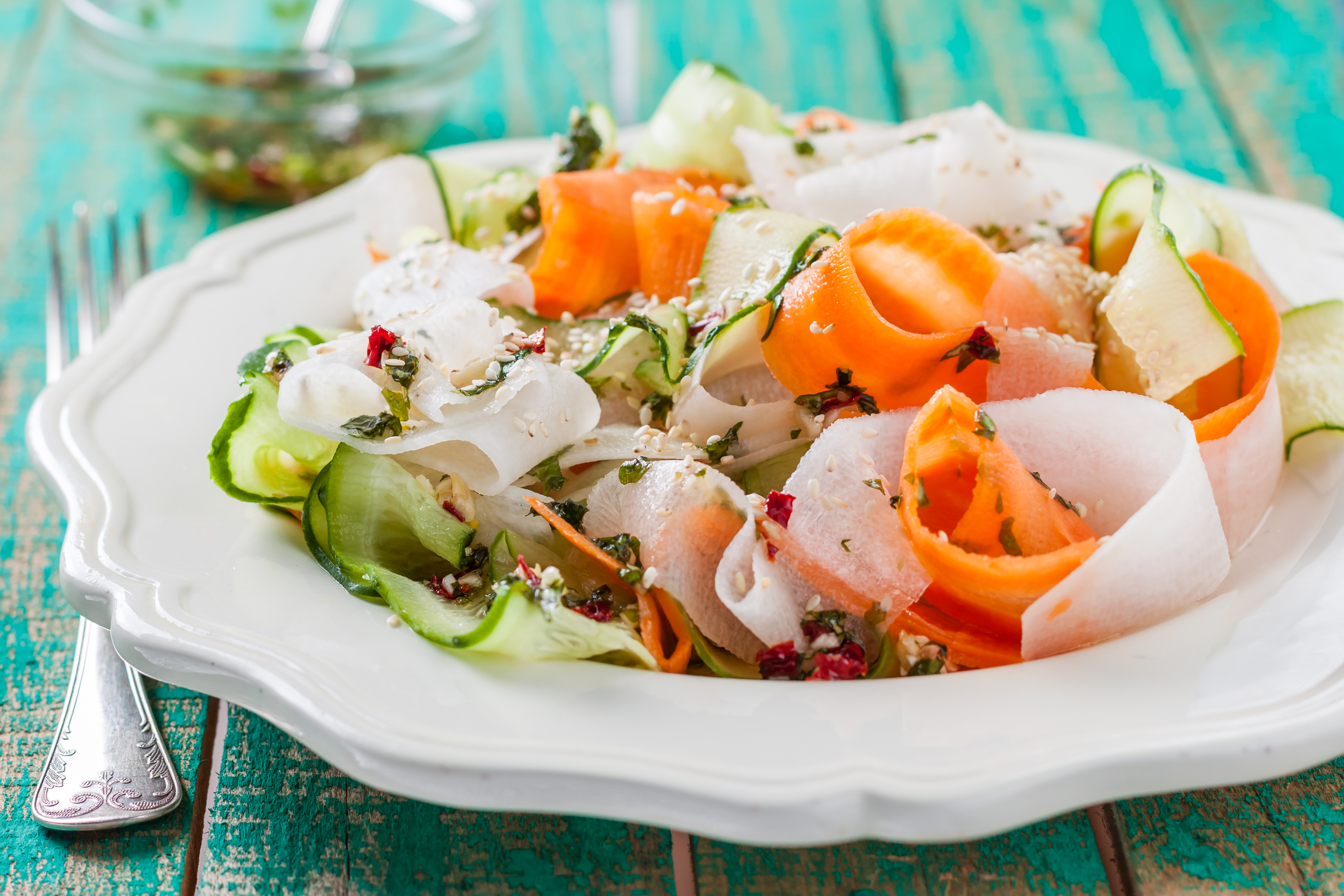 salad of carrot, cucumber and daikon radish on wooden table