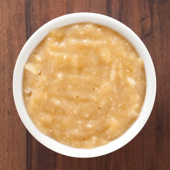Top view of white bowl full of banana puree