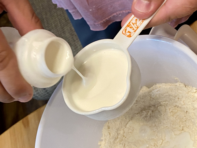 Measuring butter milk for biscuits.