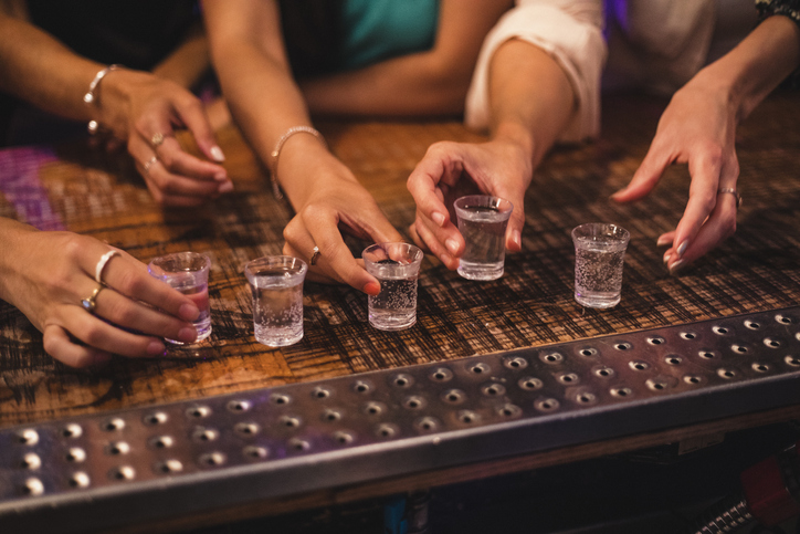 Women about to pick up some shot glasses for their night out.