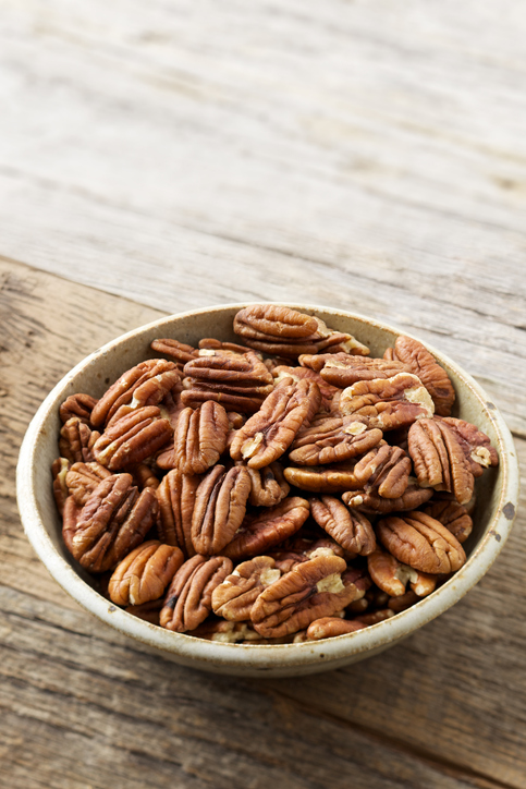 Natural light macro photo of bowl of healthy pecan nuts on old wood farm table with copyspacePlease view more rustic food images here: