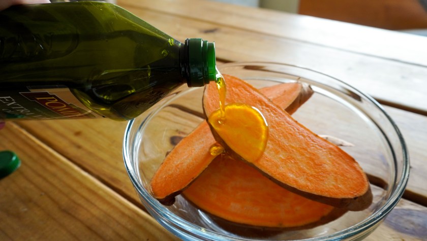 sweet potatoes with oil being drizzled on top