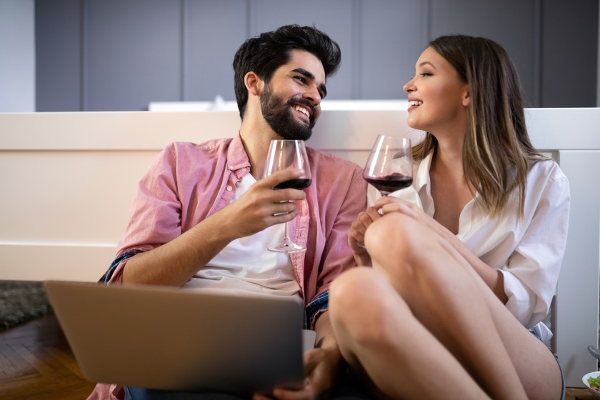Happy smiling couple using laptop at home