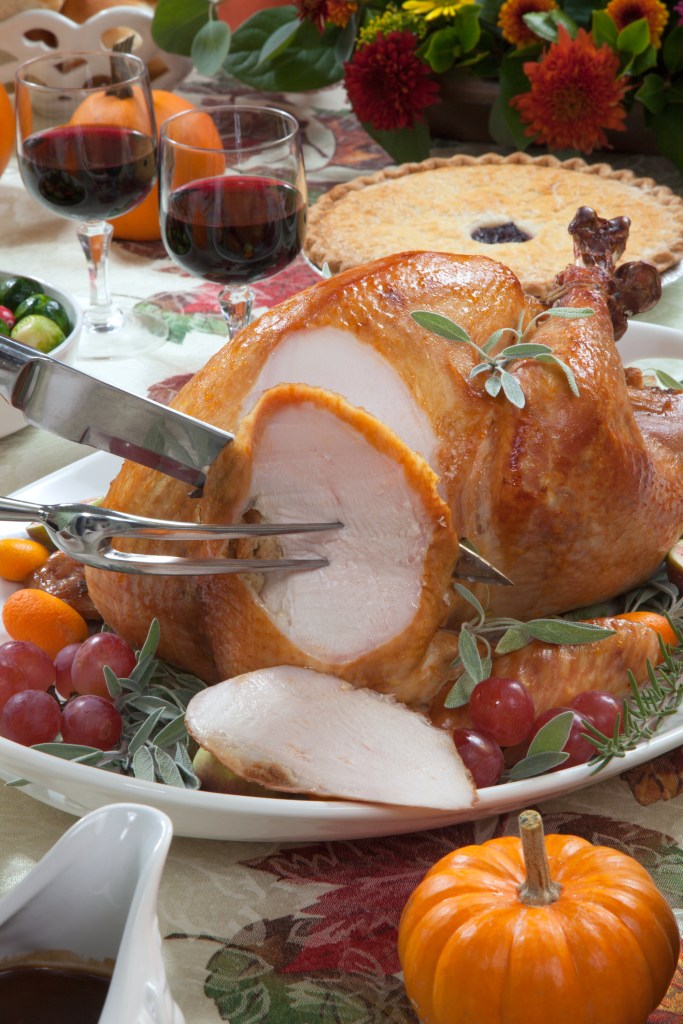 Carving roasted turkey on a server tray 