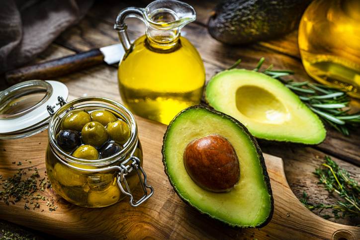 Extra virgin olive oil and avocado oil on rustic wooden table