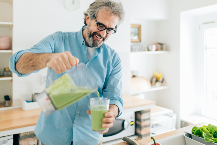 Senior man preparing smoSenior man preparing smoothie in kitchenothie in kitchen