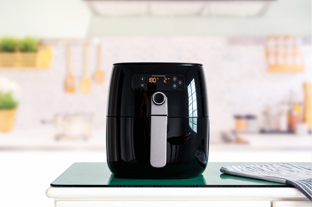 Air fryer machine cooking potato fried in kitchen.