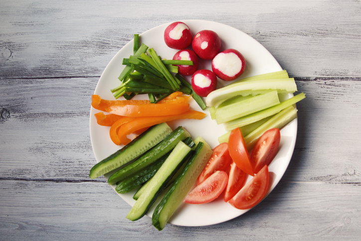 White plate with vegetables for a vegetarian salad. 
