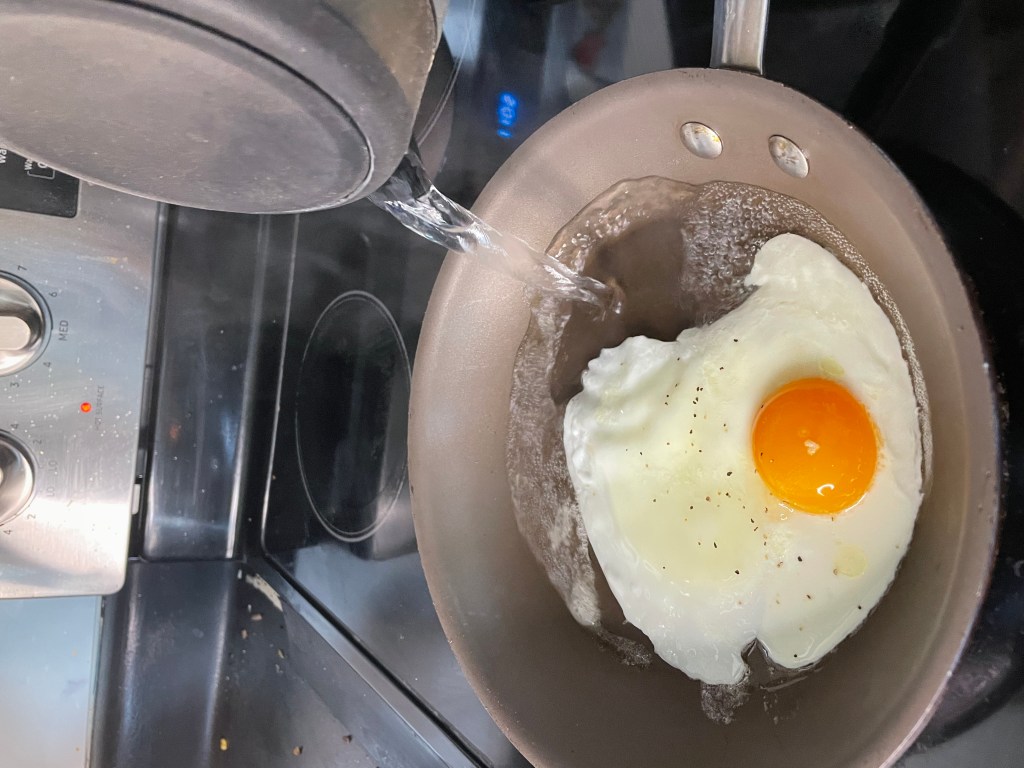 pouring water to make basted egg