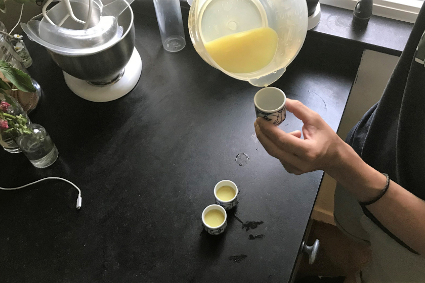 man pouring ginger shot