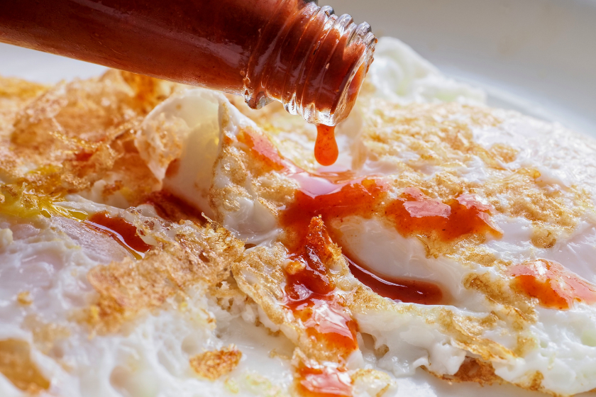 texas pete hot sauce being placed on eggs