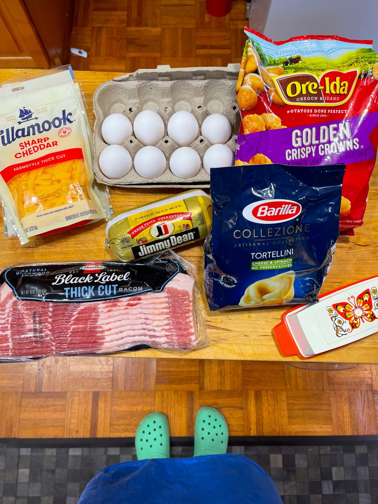 ingredients for breakfast pasta including bacon, eggs, and hashbrowns