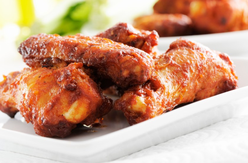 A white plate of spicy chicken wings