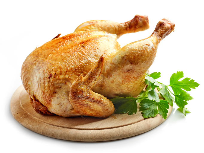 whole roasted chicken on wooden cutting board