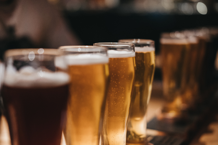 Close up of a rack of different kinds of beers, dark to light, on a table. Selective focus.