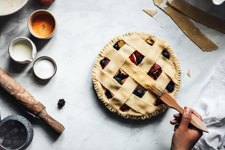 Woman working on a tasty sweet german lattice pie