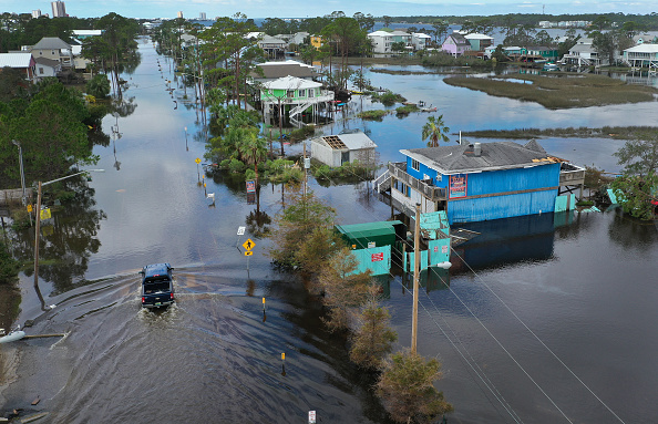 GULF SHORES, AL - SEPTEMBER 17: An aerial view from a drone shows a vehicle driving through a flooded street after Hurricane Sally passed through the area on September 17, 2020 in Gulf Shores, Alabama.