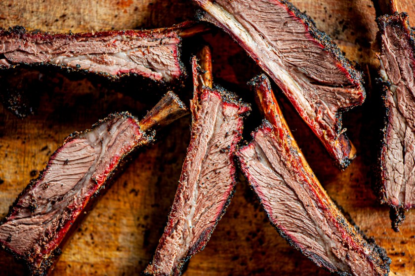 Beef ribs. Barbecue table spread. Beef brisket, chicken, pork ribs, beef ribs, Mac n cheese, cornbread, Brussels sprouts, coleslaw & beer. Classic traditional Texas meats & side dishes.