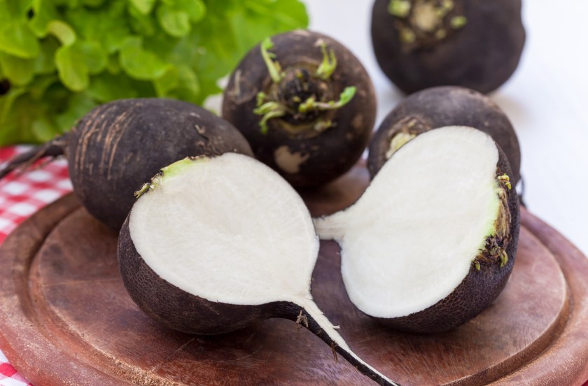 Black radish on wooden board