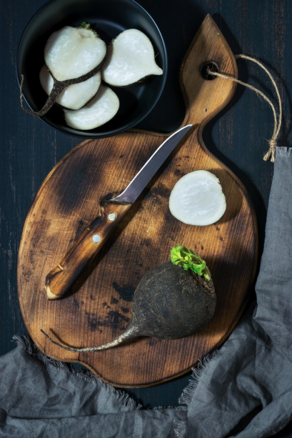 Black radish chopped slices. Black radish raw on a cutting board.