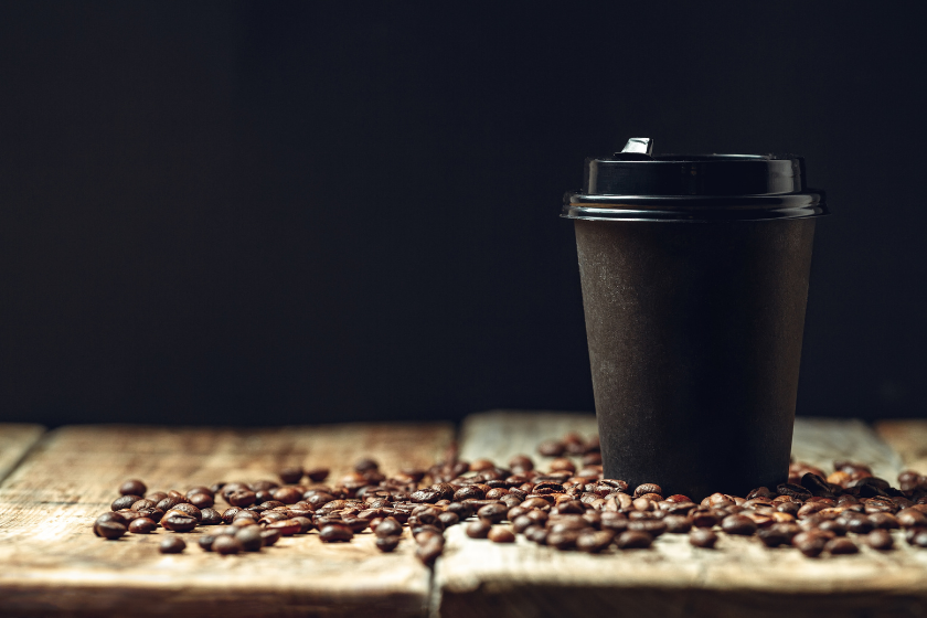 dark coffee cup on table with beans
